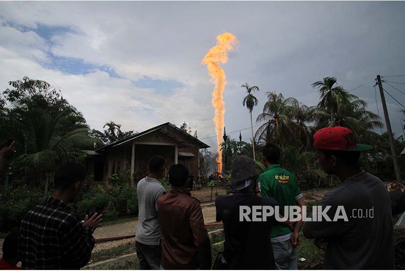 Warga menyaksikan semburan api di lokasi pengeboran minyak (ilustrasi).