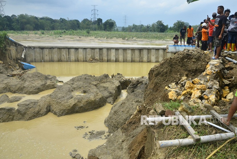 Warga menyaksikan tanggul bendungan Gelapan yang jebol di Desa Gelapan, Gubug, Grobogan, Jawa Tengah, Kamis (9/1/2020).