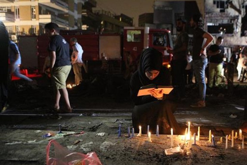 Warga menyalakan lilin di lokasi pengeboman bunuh diri di Karada, sebuah tempat perbelanjaan sibuk di Baghdad, Ahad, 3 Juli 2016. Saat itu, banyak warga sedang berbelanja untuk kebutuhan Idul Fitri.