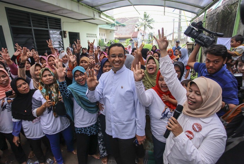 Warga menyambut kedatangan Calon Gubernur DKI Jakarta Anies Baswedan saat melakukan kampanye di kawasan Kebon Jeruk, Jakarta, Selasa (17/1). 