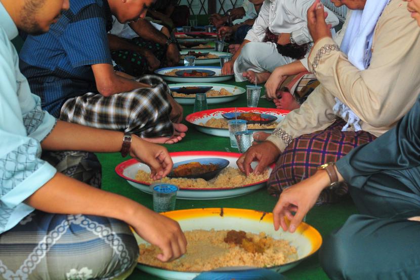 Kenali 5 Pemicu Psikologis Utama Makan Berlebihan. Warga menyantap hidangan nasi minyak khas Jambi dalam tradisi makan bersama saat perayaan Idul Fitri di Ulu Gedong, Pelayangan, Jambi.