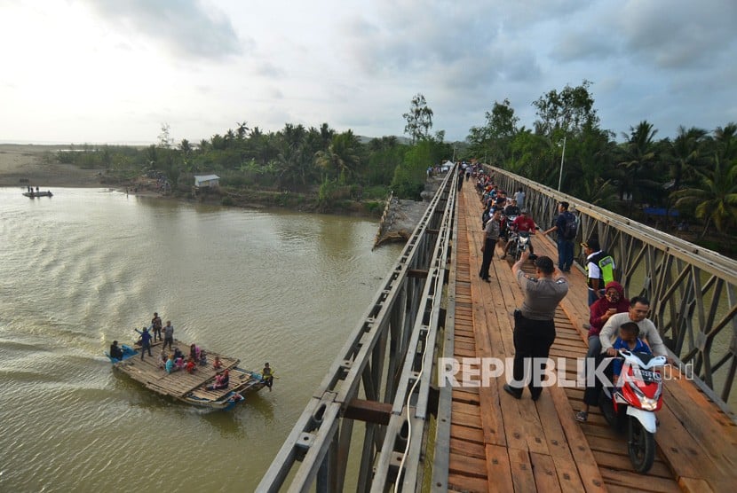 Warga menyeberang di jembatan Bailey Pansel yang baru diresmikan sebagai pengganti jembatan lama yang putus diterjang banjir bandang di Desa Ciheras, Cipatujah, Tasikmalaya, Jawa Barat, Kamis (13/12/2018).