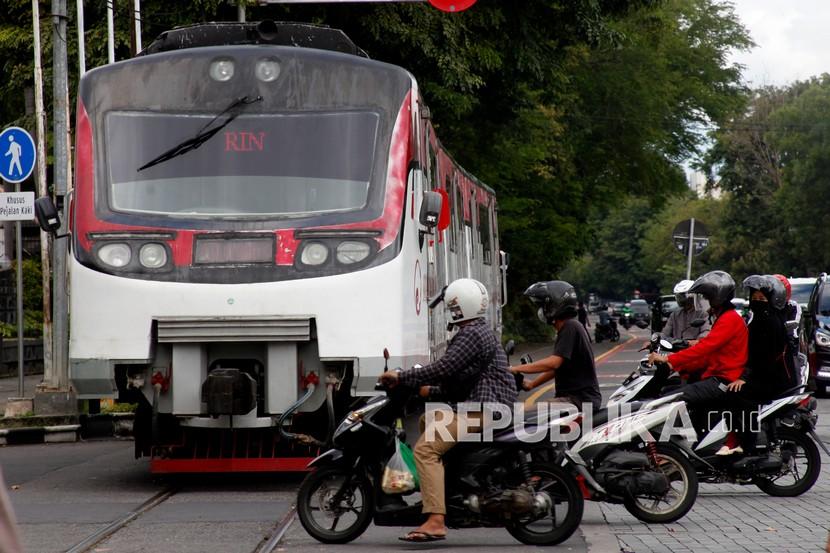 Warga menyeberangi jalan seusai Kereta Batara Kresna melintas di kawasan Gladak, Kota Solo, Jawa Tengah, Rabu (9/3/2022). 