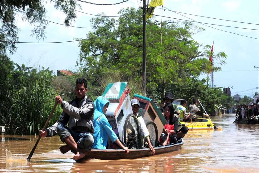  Warga menyebrang wilayah banjir dengan mengunakan ojeg perahu di Baleendah Kabupaten Bandung, Senin(3/3).  (foto: Septianjar Muharam)