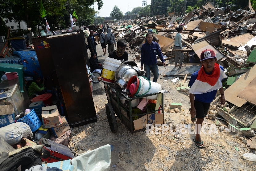 Warga menyelamatkan barang miliknya saat dilakukan penertiban permukiman warga di Rawajati, Jakarta, Kamis (1/9).
