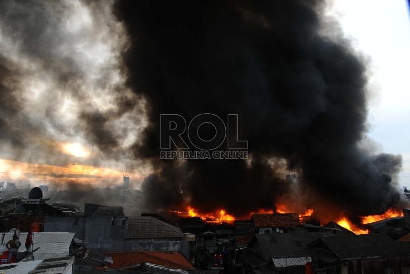  Warga menyelamatkan barang saat api melahap pemukiman padat di kawasan Kebon Melati, Tanah Abang, Jakarta Pusat, Kamis (5/3). (Republika/Tahta Aidilla)