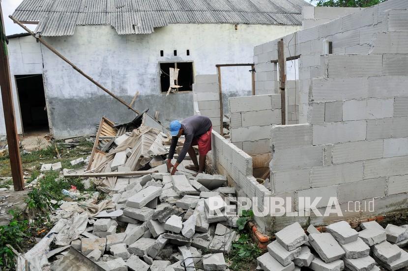 Warga merapikan bagian rumahnya yang rusak usai terjangan angin puting beliung di Desa Sukadaya, Sukawangi, Kabupaten Bekasi.