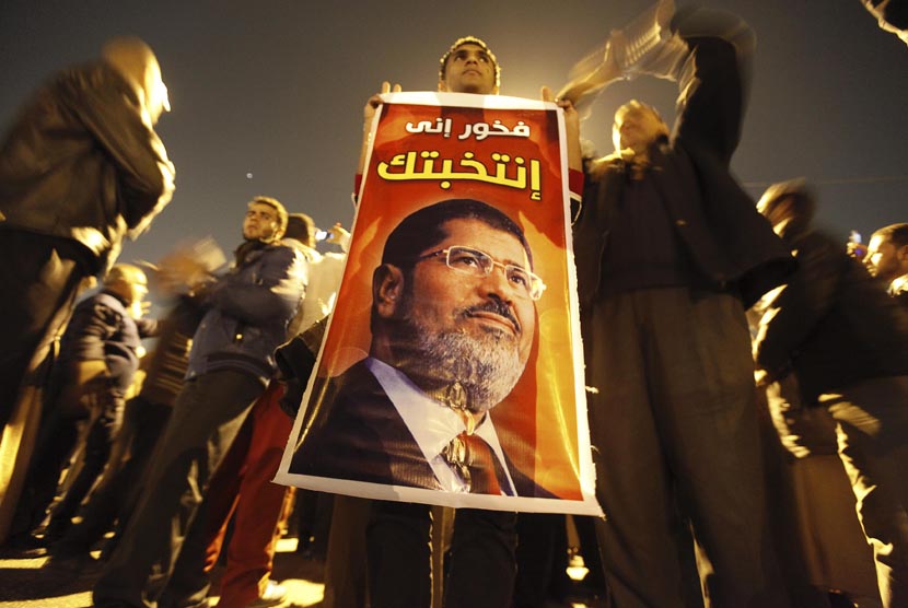 Warga Mesir pendukung Presiden Muhammad Mursi memberikan dukungannya dalam aksi unjuk rasa di Rabaa El Adaweya di Kairo, Ahad (9/12). (Reuters/Amr Abdallah Dalsh)  
