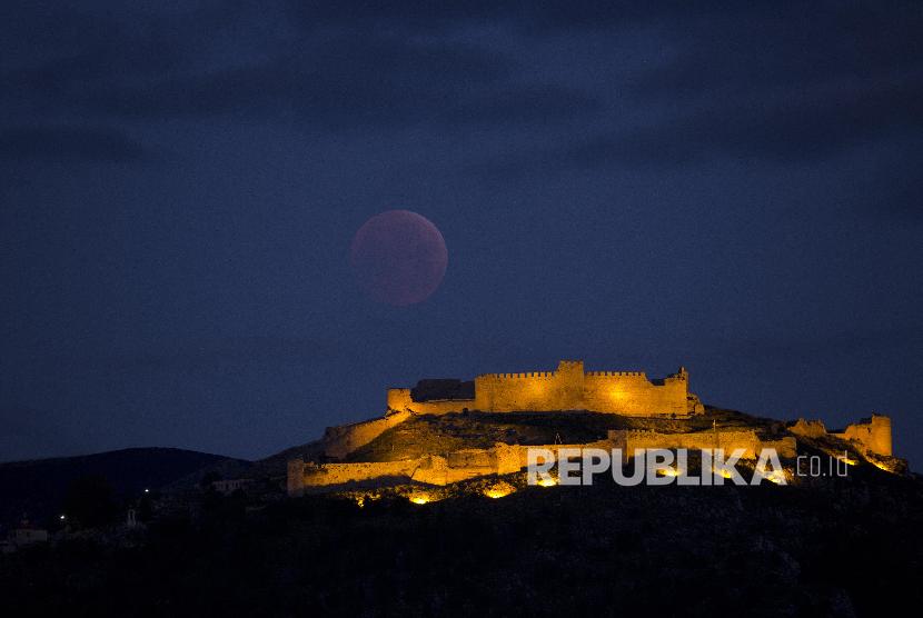 Bulan purnama supermoon tenggelam dengan latar depan pemandangan situs kota kuno Argos di Yunani (20/1) waktu setempat.