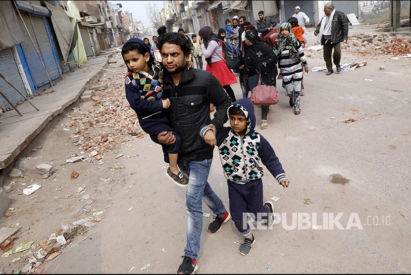 Warga muslim meninggalkan lingkungan rumahnya yang mayoritas warga Hindu pascabentrok massa pendukung dan penentang UU Kewarganegaraan India berujung rusuh di New Delhi, India.