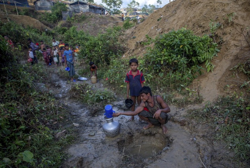 Warga Muslim Rohingya, yang menyeberang dari Myanmar ke Bangladesh, mengumpulkan air hujan di kamp pengungsi Balukhali, Bangladesh, Rabu (13/9). 