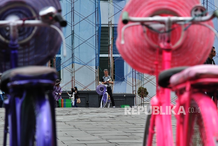 Turis menaiki sepeda onthel saat mengunjungi kawasan wisata Kota Tua, Jakarta. Di Indonesia sepeda dulu pernah menjadi simbol status sosial.