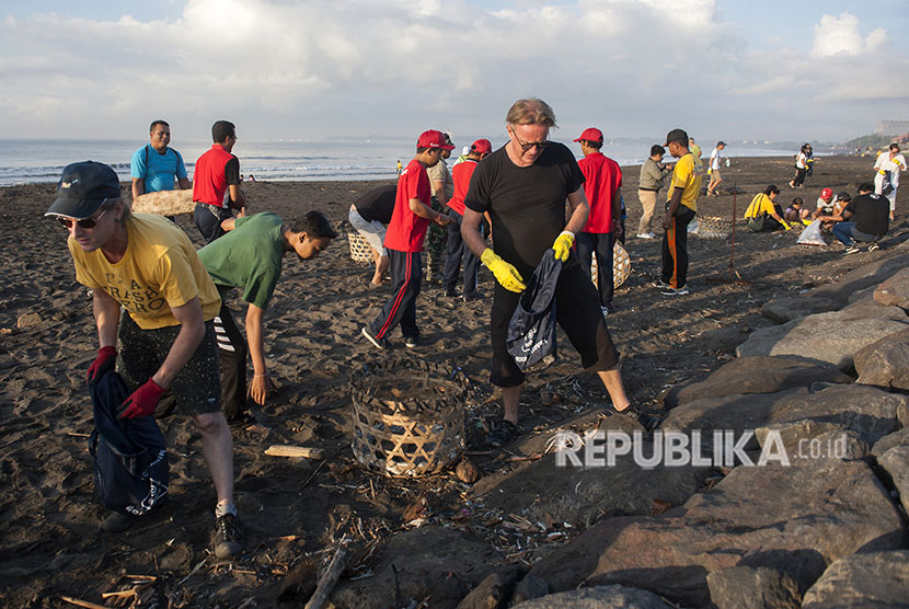 Warga negara Australia bersama masyarakat Bali memungut sampah plastik yang berserakan di Pantai Biaung, Denpasar, Bali, Sabtu (2/6).