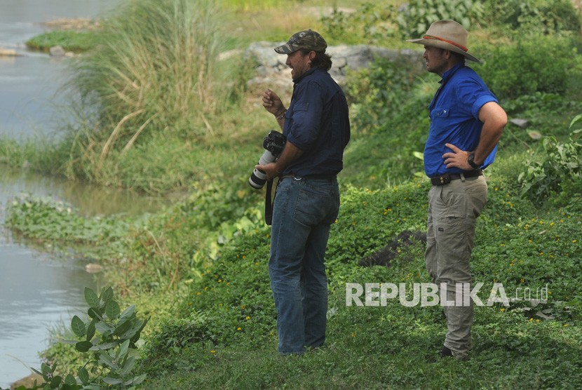 Warga negara Australia, Matthew Nicolas Wright (kiri) dan Chris Wilson (kanan) memantau lokasi kemunculan seekor buaya liar yang terjerat ban sepeda motor di Sungai Palu di Palu, Sulawesi Tengah, Selasa (11/2/2020).