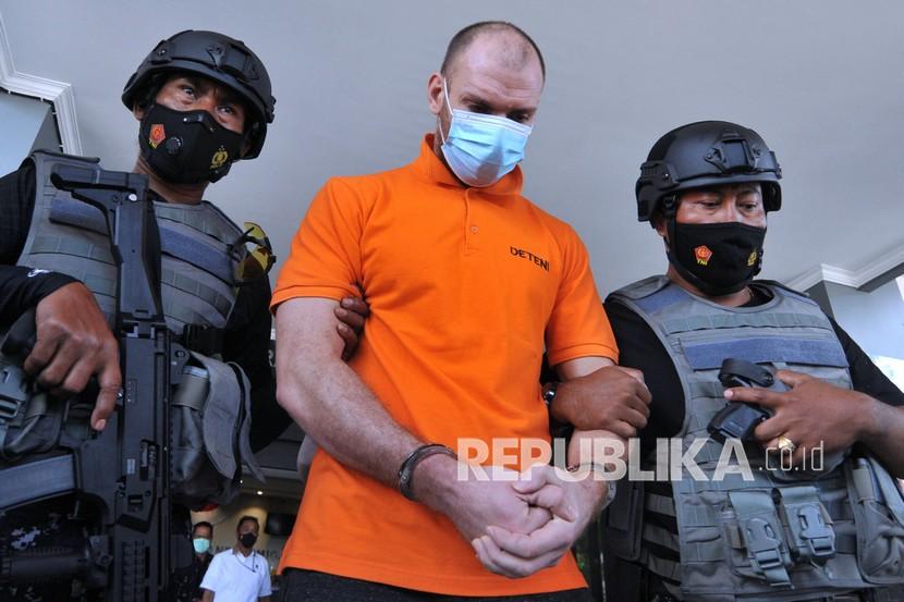 Warga negara Rusia Andrey Kovalenko alias Andrew Ayer (tengah) digiring petugas saat dideportasi di Kantor Imigrasi Kelas I Khusus TPI Ngurah Rai, Kabupaten Badung, Bali, Selasa (23/3/2021). 