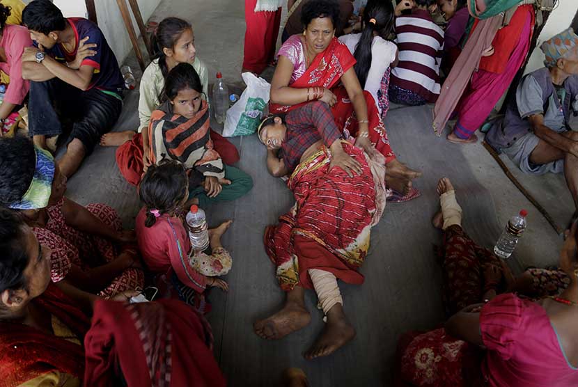  Warga Nepal yang terluka akibat gempa bumi menunggu dievakuasi di Trishul Bazar, Nepal, Senin (27/4). 