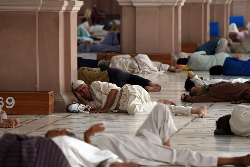 Warga Pakistan beristirahat di masjid untuk menghindari gelombang panas yang mencapai 44 derajat Celsius, Senin (22/6).