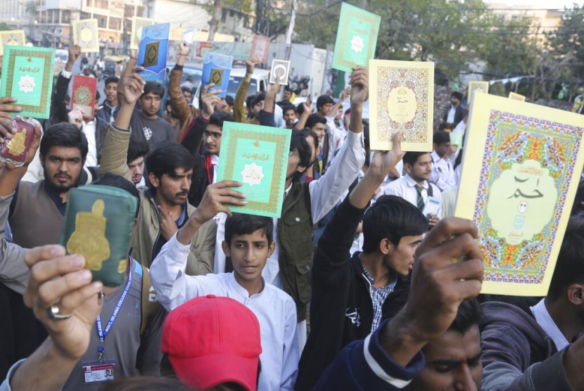 Warga Pakistan mengangkat tinggi Alquran di kepala dalam aksi protes di Lahore, Pakistan, Sabtu (23/11). Warga memprotes aksi bakar Alquran yang dilakukan oleh demonstran anti-Islam pekan lalu.