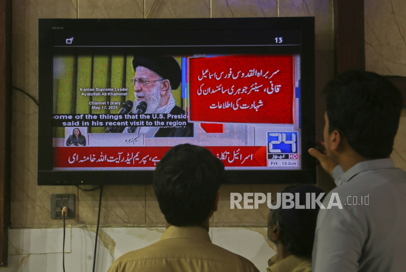 Warga Pakistan menyaksikan saluran berita yang menyiarkan laporan tentang serangan Israel terhadap Iran, di Peshawar, Pakistan, Jumat, 13 Juni 2025.