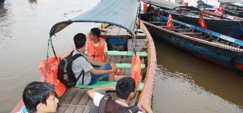 Warga Palembang menikmati perahu kayu gratis SEA Games 2011 yang disediakan pemkot setempat di Dermaga Bawah Jembatan Ampera.