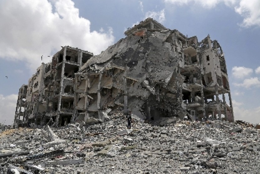Warga Palestina di Gaza mencari barang-barang yang bisa diselamatkan dari reruntuhan rumahnya yang hancur dibom militer Israel.