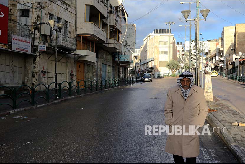 Warga Palestina melintasi jalanan yang kosong karena aksi mogok massal di Kota Nablus, Tepi Barat, Palestina.