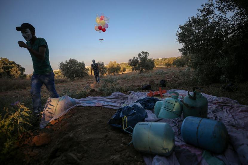 Warga Palestina melepaskan balon yang dilengkapi alat pembakar ke ladang Israel di dekat perbatasan Jalur Gaza Timur, 12 August 2020. Pada Jumat (6/8/2021), Israel menjatuhkan bom dari atas langit Gaza setelah diserang oleh balon pembakar.