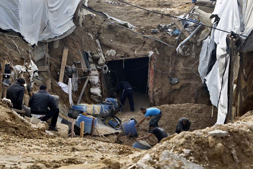 Warga Palestina membangun kembali terowongan yang hancur di sepanjang perbatasan Gaza Mesir di Rafah, bagian selatan Jalur Gaza, Selasa (27/11).   (AP/Adel Hana)