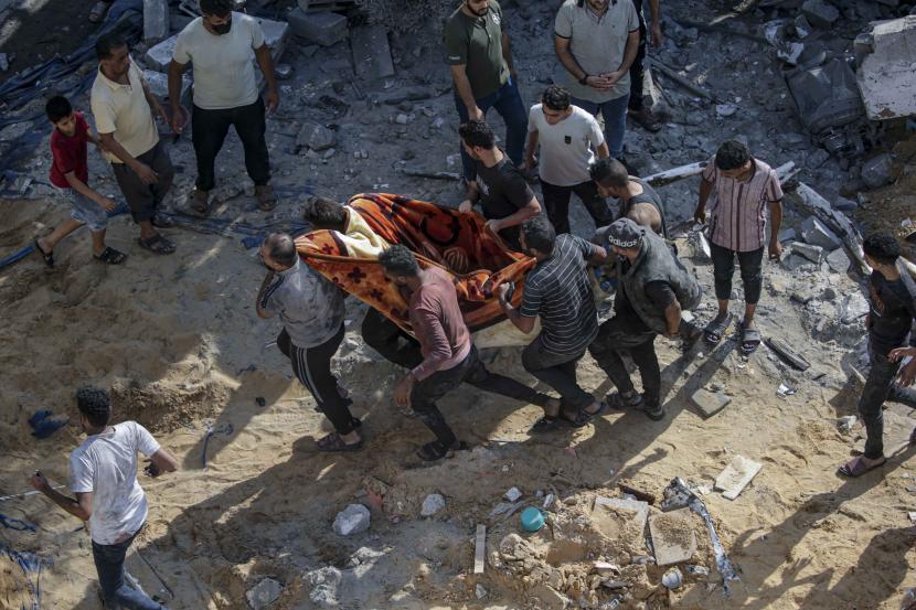 Warga Palestina membawa jenazah pria yang meninggal setelah serangan udara Israel di Al Falouja di kota Jabalia, Gaza utara.
