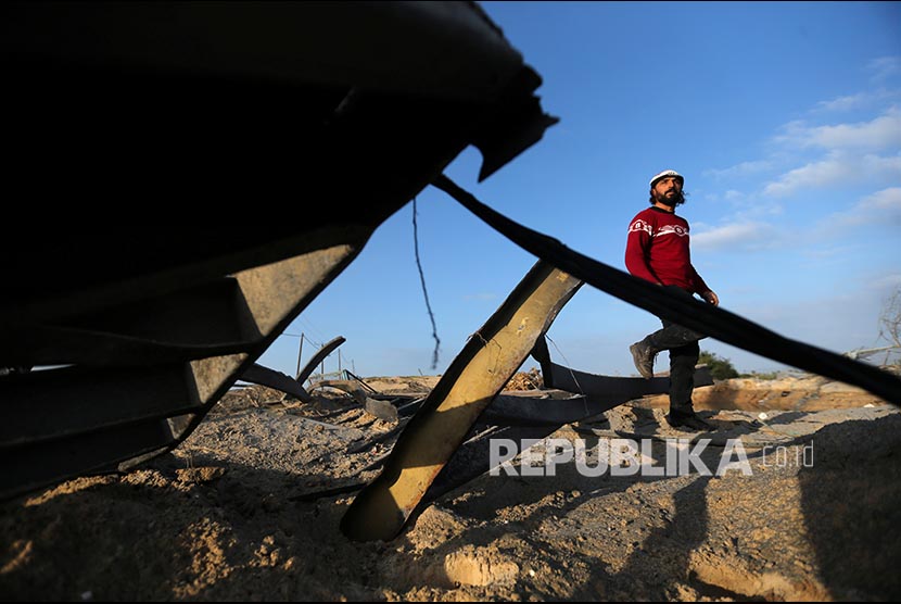 Warga Palestina memerika lokasi  serangan udara militer Israel di selatan Jalur Gaza, Jumat (31/1)