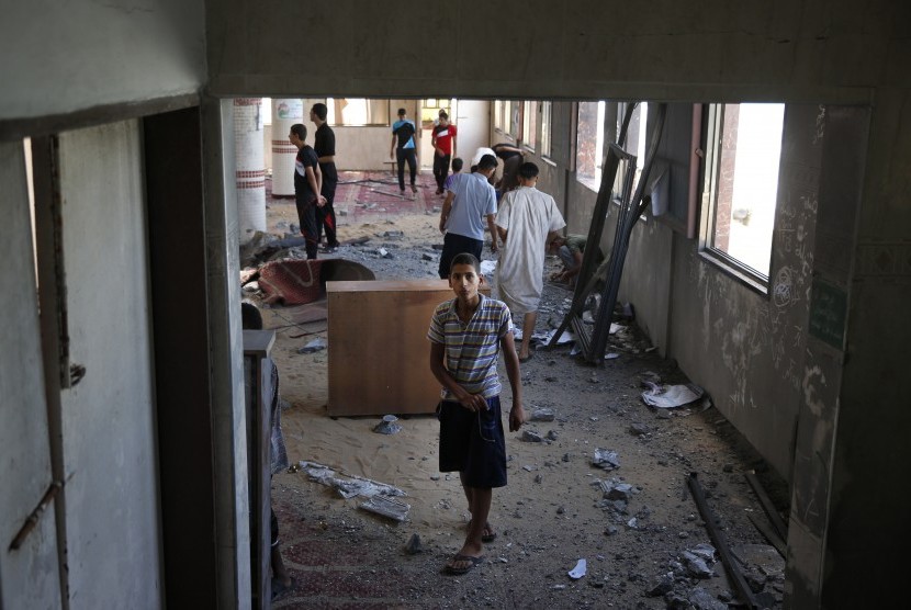 Warga Palestina memeriksa masjid yang hancur karena serangan misil Israel di Jalur Gaza, Senin (14/7).