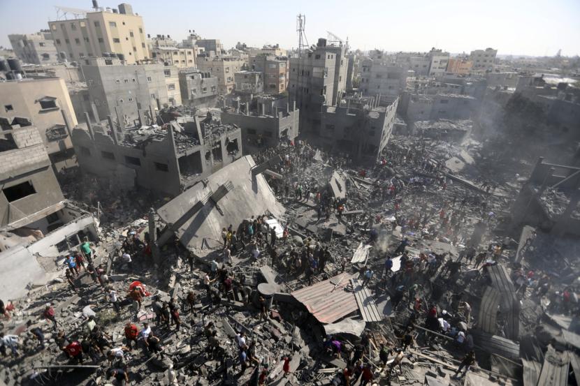 Warga Palestina memeriksa puing-puing bangunan yang hancur akibat serangan udara Israel di kota Khan Younis, Jalur Gaza selatan, Kamis, 26 Oktober 2023. 
