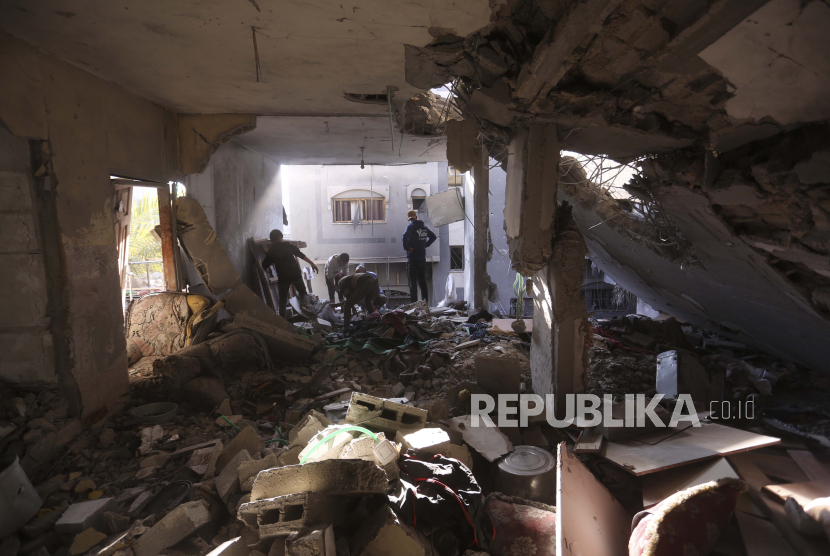 Warga Palestina memeriksa rumah yang hancur akibat bombardir pasukan zionis Israel di Rafah, Jalur Gaza, Kamis (7/12/2023).