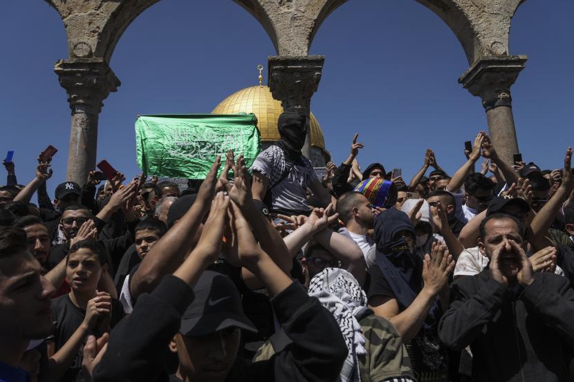 Warga Palestina meneriakkan slogan-slogan dan mengibarkan bendera Hamas selama protes terhadap Israel, di depan kuil Dome of the Rock di kompleks Masjid Al Aqsa di Kota Tua Yerusalem, Jumat, 15 April 2022.