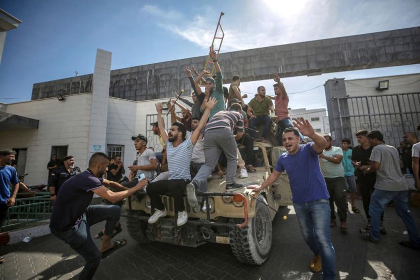 Warga Palestina mengendarai jip militer Israel di jalan-jalan Gaza selama penyerbuan permukiman Israel oleh Hamas.