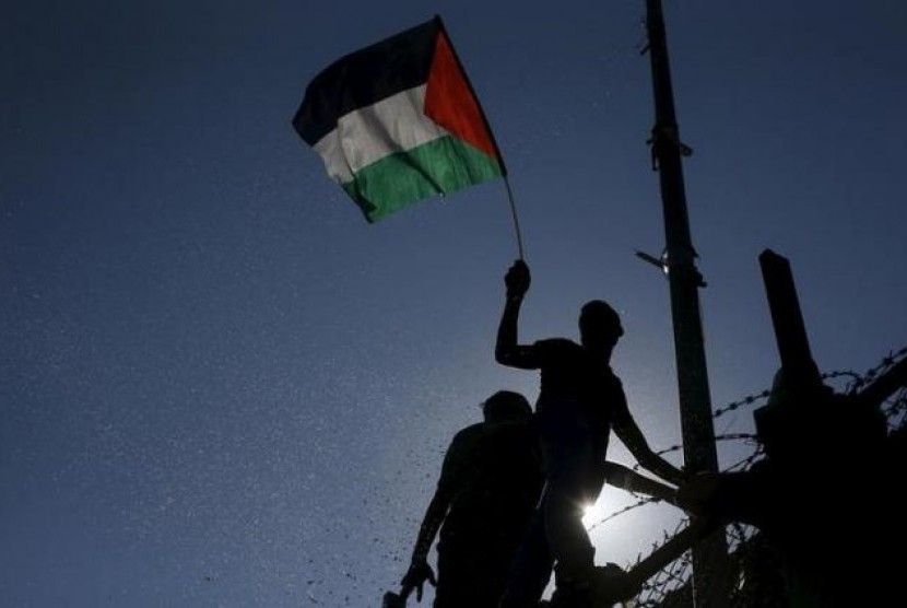 Warga Palestina mengibarkan bendera.