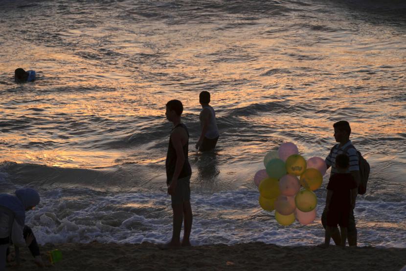 Warga Palestina menikmati pantai di sepanjang Laut Mediterania selama liburan Jumat mereka di Beit Lahia, Jalur Gaza utara, Jumat, 22 Juli 2022.