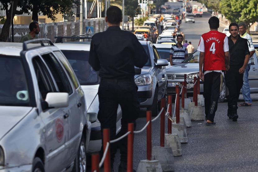 Warga Palestina menunggu dalam antrean untuk mengisi bahan bakar mobil mereka di sebuah  SPBU di Kota Gaza, Senin, (2/9).   (AP/ Adel Hana)
