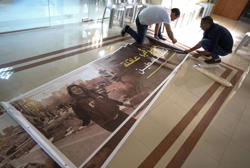 Warga Palestina menyiapkan poster bergambar jurnalis Al Jazeera Shireen Abu Akleh dan berbahasa Arab bertuliskan, Shireen, nadi Palestina, di kantor saluran Al Jazeera, di kota Ramallah, Tepi Barat, Rabu, 11 Mei 2022.