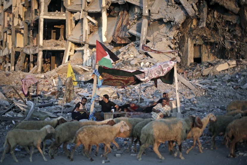 Warga Palestina sedang duduk di tempat perlindungan yang terbuat dari selimut di Gaza