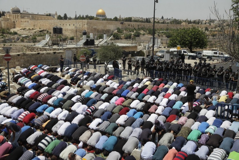 Palestinians perform Friday prayers in the outskirt of Jerusalem Old Town, Friday (July 21). 