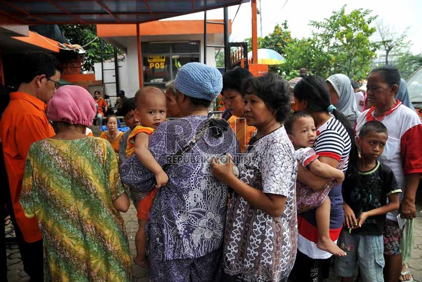  Warga pemegang kartu perlindungan sosial (KPS) mengantre untuk menerima Bantuan Langsung Sementara Masyarakat (BLSM) di Kantor Pos Jatinegara, Jakarta Timur, Senin (2/9).   (Republika/Prayogi)