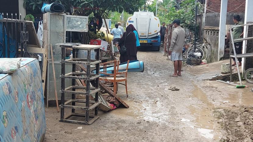 Warga perumahan klaster Dinar Indah, Keluraha Meteseh, Kecamatan Tembalang, Kota Semarang, dibantu para relawan membersihkan lumpur yang terbawa sisa banjir bandang di lingkungan mereka, Ahad (8/1).