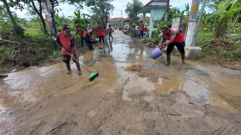 Warga perumahan klaster Dinar Indah, Kelurahan Meteseh, Kecamatan Tembalang, Kota Semarang dibantu para relawan membersihkan lumpur yang terbawa sisa banjir bandang di lingkungan mereka, Ahad (8/1/2023).
