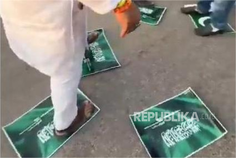 Warga Prayagraj di Negara Bagian Uttar Pradesh, India, menginjak poster bertuliskan bertuliskan Kalimatullah (La ilaha Illallah Muhammadur Rasulullah) dan bendera Pakistan.