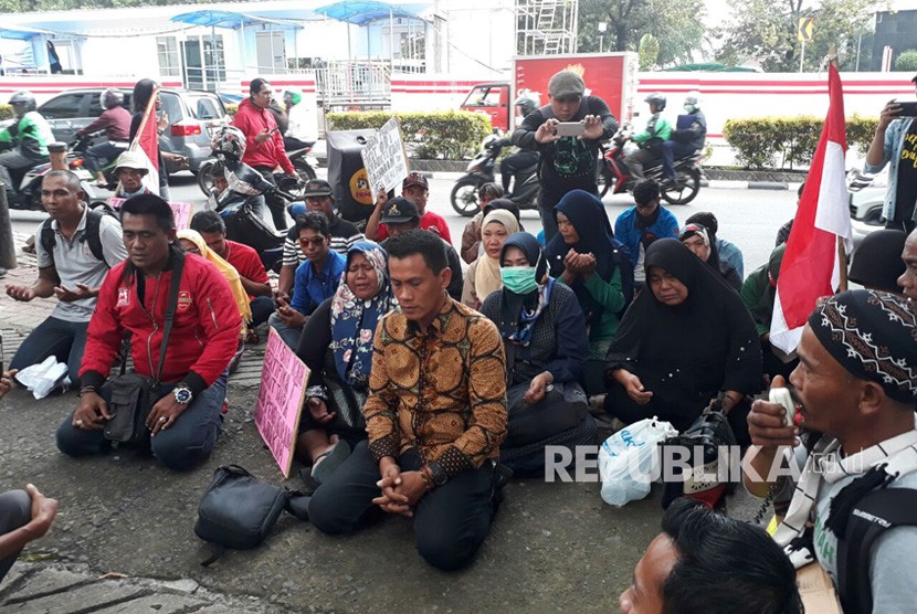 Warga Pulau Pari berdoa bersama di depan Kantor Ombudsman RI, Jalan HR Rasuna Said, Jakarta Selatan, Senin (9/4). 