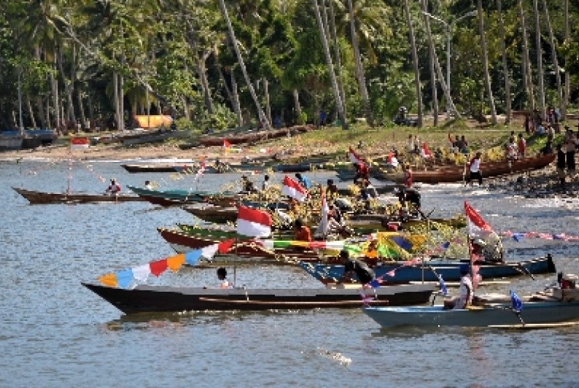 Warga Raja Ampat mengikuti llomba perahu ketinting di Pantai Waisai Tercinta.