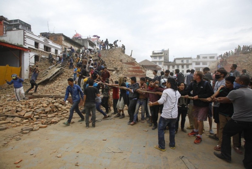 Warga saling bahu-membahu mengangkat reruntuhan di gempa Nepal.