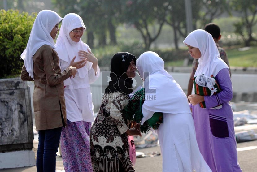  Warga saling memaafkan dan berjabat tangan usai mengikuti Shalat Idul Fitri di pelataran jalan Pasar Senen, Jakarta Pusat, Kamis (8/8).  (Republika/ Yasin Habibi)