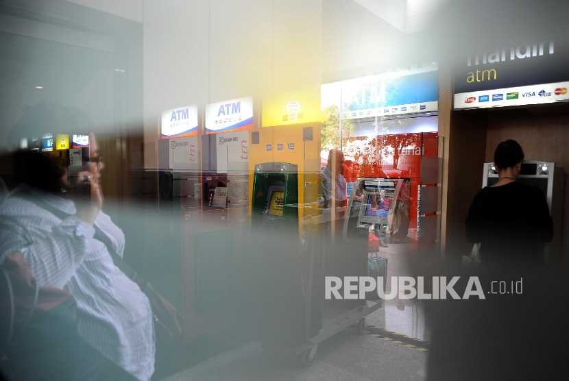 Warga sedang mengunakan Anjungan Tunai Mandiri di ATM Centre, Jakarta
